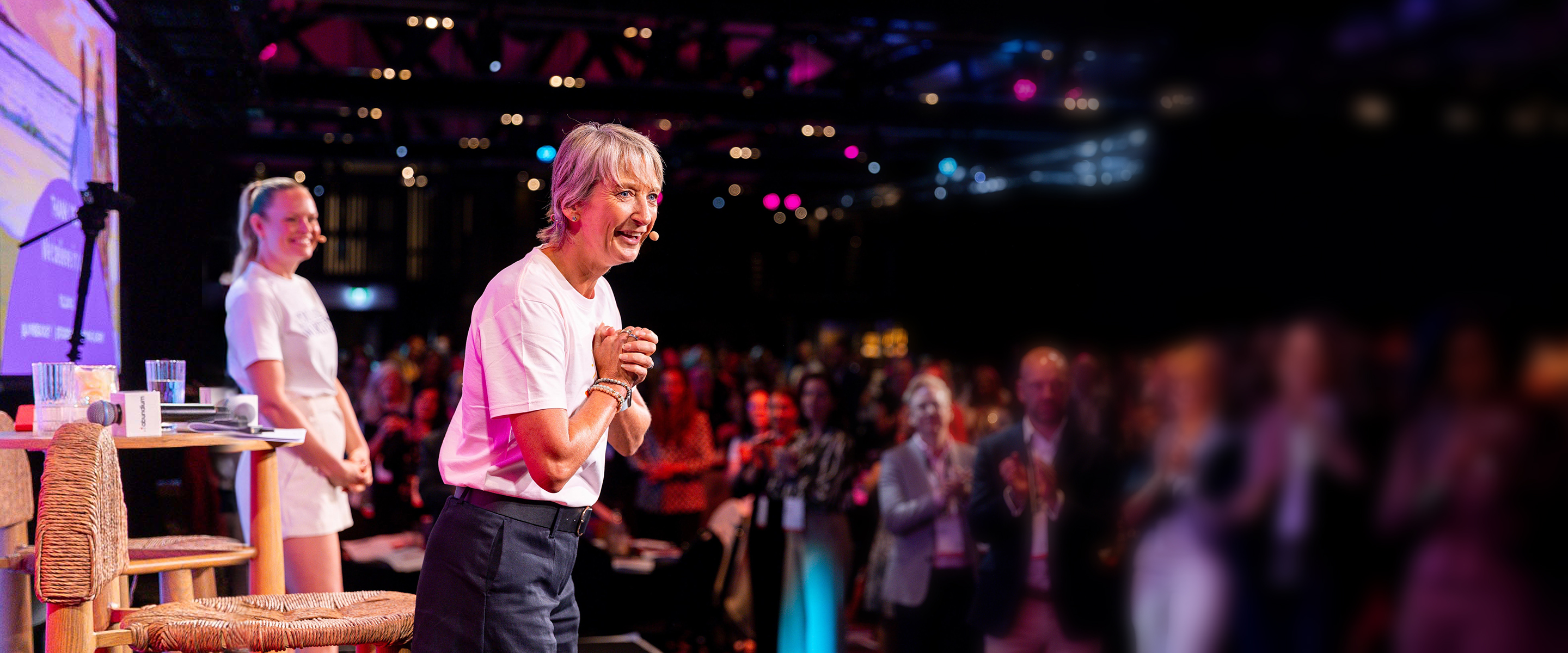 Layne Beachley on stage at an Awake keynote, with the audience applauding
